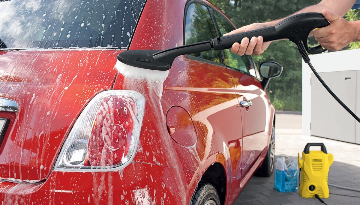 Myjka wysokociśnieniowa K 2 Car firmy Karcher. Mężczyzna myje samochod szczotką Soft clean z białym włosiem za pomocą myjki K 2 w zestawie Car.